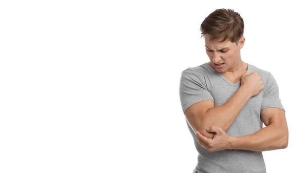 Απελπισμένη χιλιετή ευρωπαϊκό αρσενικό που πάσχουν από πόνο στον αγκώνα, πιέζει το χέρι σε επώδυνο σημείο — Φωτογραφία Αρχείου
