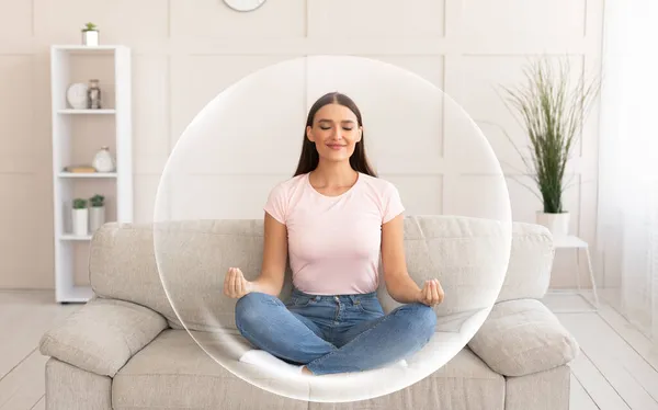 Pacyficzny spokój usatysfakcjonowany uśmiechnięty millenium Europejczyk kobieta medytuje na kanapie w salonie wnętrze — Zdjęcie stockowe
