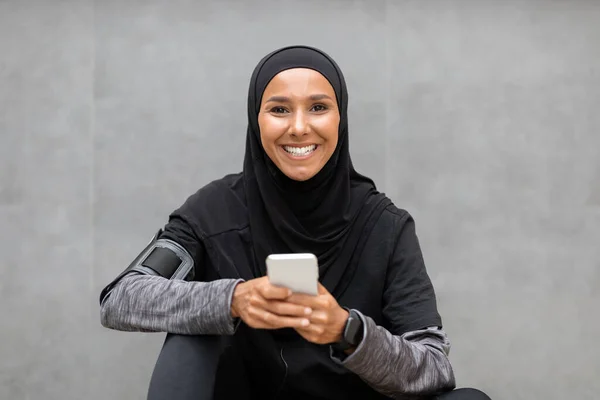 Happy Young Muslim Woman In Sportswear Relaxing With Smartphone After Outdoor Training (dalam bahasa Inggris) — Stok Foto