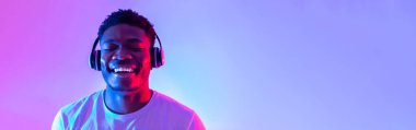 Yakışıklı siyah adam kulaklık takıyor, kapalı gözlerle müzik dinliyor, afiş tasarımı yapıyor
