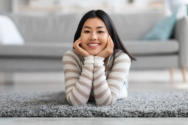 Portret van mooi jong aziatisch vrouw ontspannen op de vloer in woonkamer — Stockfoto