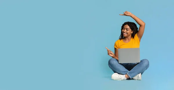 Happy black woman with laptop pointing at copy space — Stock Photo, Image