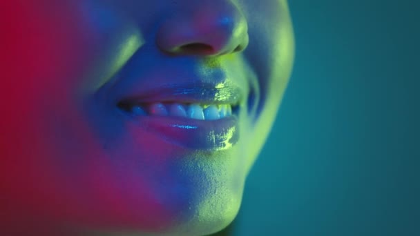 Оральный уход и стоматологическая эстетика. Полупрофиль снимок неузнаваемой леди, улыбающейся в сторону, позирующей в флуоресцентных лампах — стоковое видео
