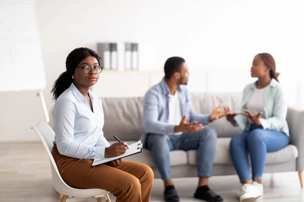 Kadın psikolog ve genç siyah çift iş yerindeki evlilik terapisi sırasında anlaşmazlık yaşıyorlar. — Stok fotoğraf