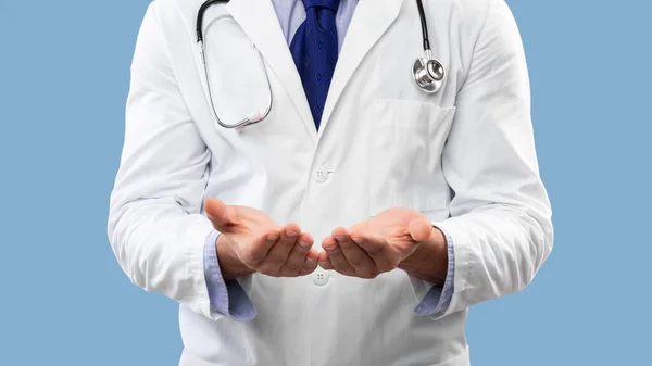Nierozpoznawalne Mężczyzna lekarz pokazuje niewidzialny obiekt na niebieskim tle, Panorama — Zdjęcie stockowe
