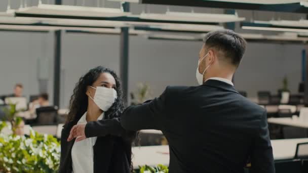 Homme d'affaires et femme d'affaires portant des masques cogner les coudes parler au bureau — Video