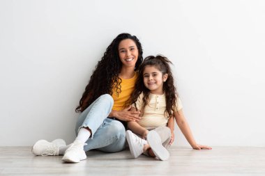 Sevimli genç Arap anne ve onun kadın çocuğu evde birlikte dinleniyorlar.