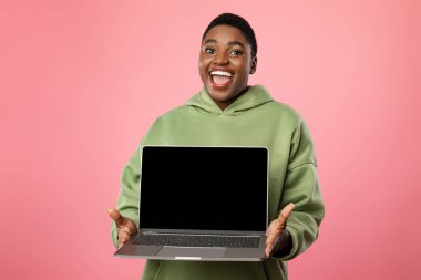 Pembe Arkaplan Üzerinde Dizüstü Bilgisayarı Gösteren Şişman Afrikalı Kadın Ekranı