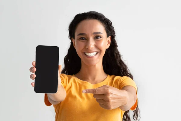 Gran aplicación. Alegre mujer milenaria señalando a Smartphone con pantalla negra — Foto de Stock
