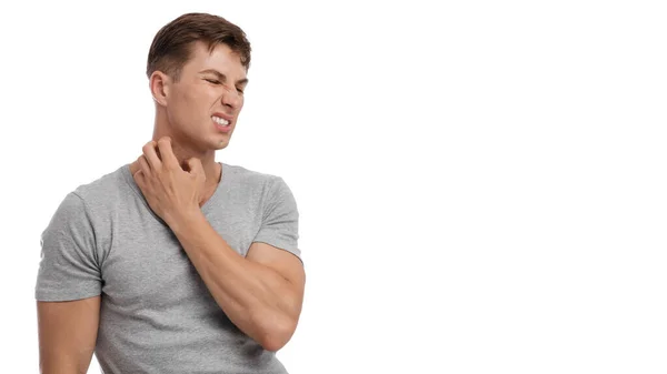 Upset young caucasian male suffering from irritation and scratching skin on neck, with painful facial expression — Stock Photo, Image