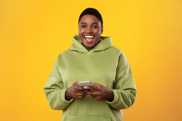 Oversized Black Woman Using Smartphone Over Yellow Studio Background — 스톡 사진