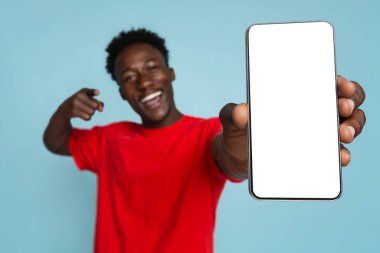 Cep telefonu reklamı. Neşeli siyah adam elinde boş akıllı telefonu işaret ediyor.