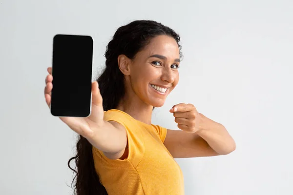 Mobiel aanbod. Jonge vrouw houden en wijzen op Smartphone met blanco scherm — Stockfoto
