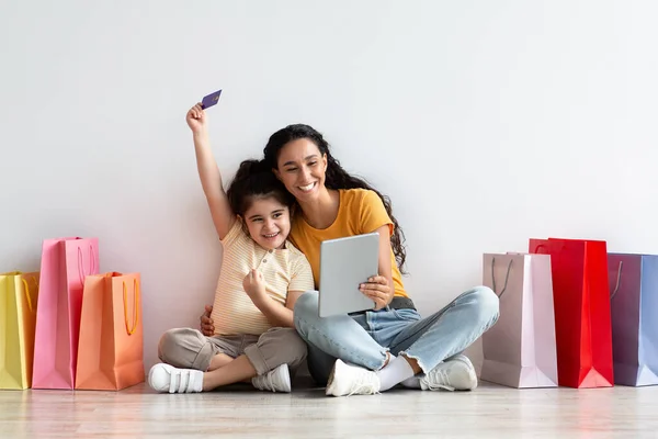 Küçük kız ve annesi dijital tablet ve kredi kartıyla alışveriş yapıyorlar. — Stok fotoğraf