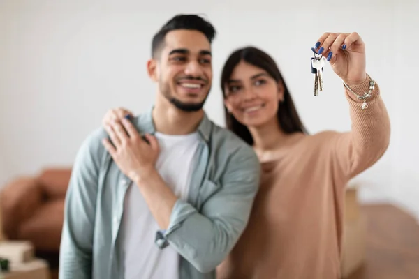 Glückliches Paar zeigt Schlüssel seiner Wohnung, selektiver Fokus — Stockfoto