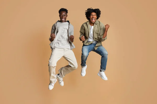 Μεγάλη Χαρά. Δύο ευτυχισμένοι μαύροι που πηδούσαν στον αέρα και γιόρταζαν την επιτυχία — Φωτογραφία Αρχείου