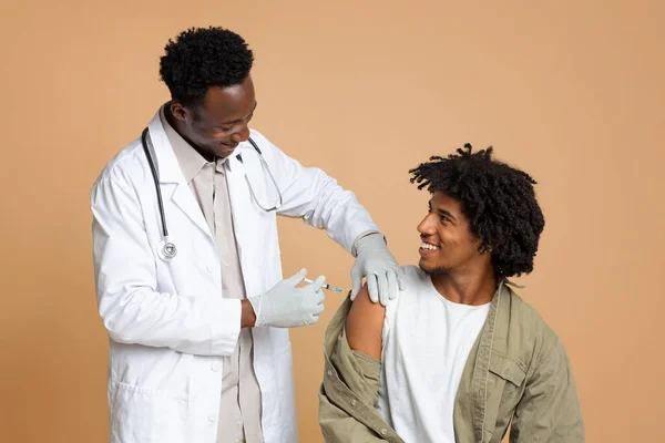 Coronavirus Vaccination Campaign. African American Male Patient Getting Vaccine Injection Against Covid-19