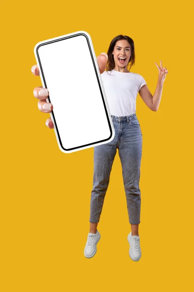 Beyaz, boş, akıllı telefon ekranı gösteren ve zıplayan kadın — Stok fotoğraf