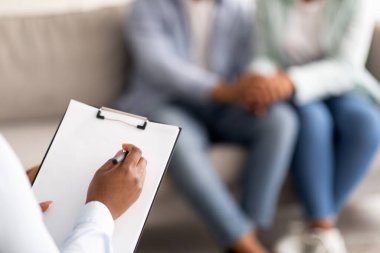 Siyahi evli çiftlerin ve psikoterapistlerin etkin oturumdan sonra ofiste yakın çekimleri, seçici odaklanma