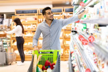 Arap Adam marketten mandıra ürünleri alıyor.