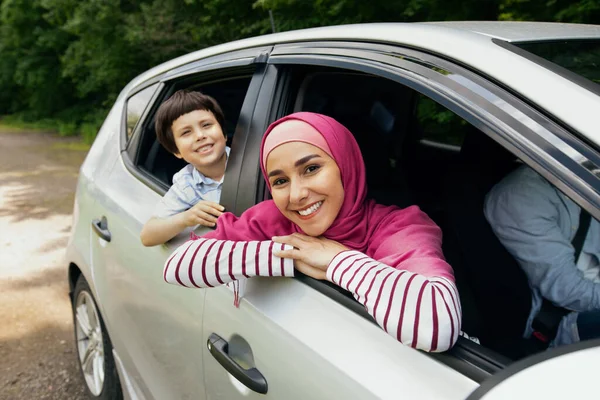 Moslim familie paardrijden auto samen, moeder en zoon leunend uit ramen — Stockfoto