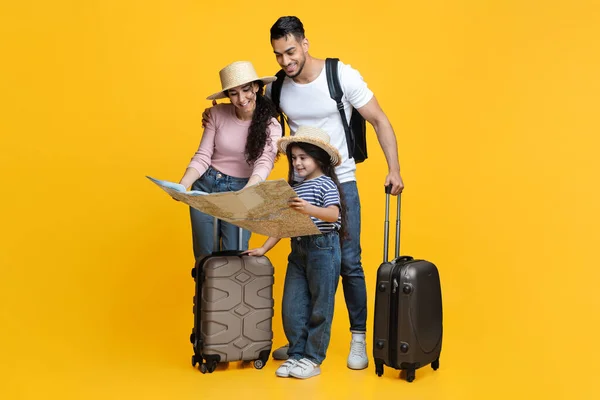 Joyeux jeune famille avec petite fille regardant la carte, la planification des voyages — Photo