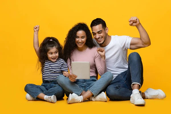 Online Offer. Happy arab family of three celebrating success with digital tablet — Stock Photo, Image