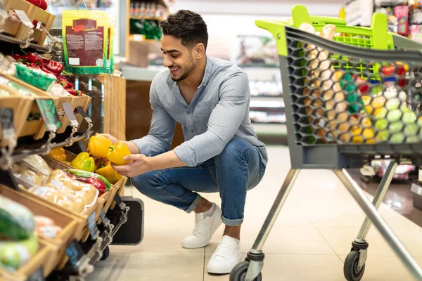 スーパーで食料品の買い物をする野菜を買う幸せなアラブ男 — ストック写真