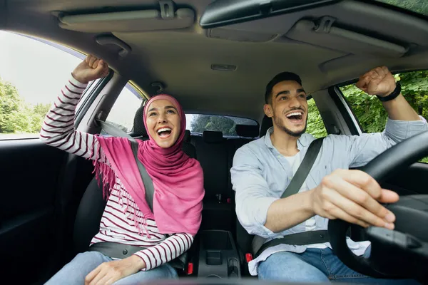 Een reisje. Opgewonden gelukkig moslim echtgenoten hebben plezier tijdens het rijden auto samen — Stockfoto