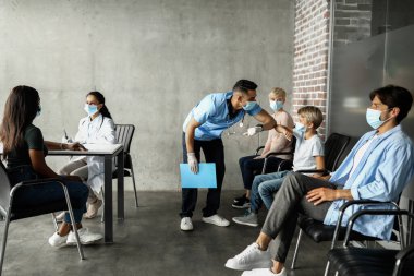 Orta Doğulu doktor dirsek darbesi olan genç hastayı selamlıyor.