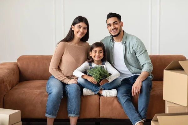 Позитивная молодая семья смотрит в камеру, позирует на диване — стоковое фото