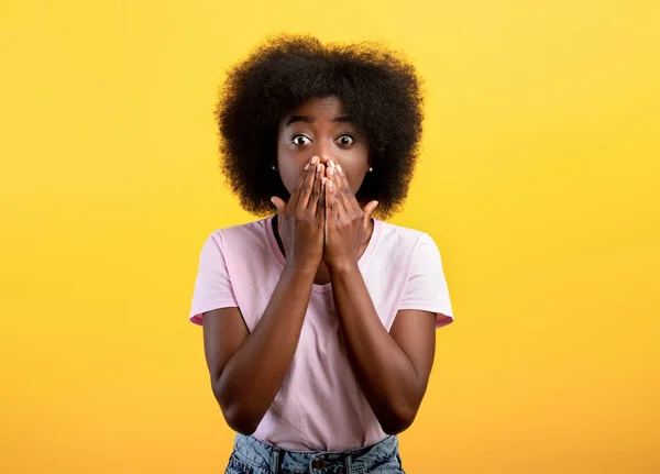 Omg. Chocado Africano americano senhora cobrindo boca com as mãos e olhando para a câmera com medo, fundo amarelo — Fotografia de Stock