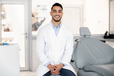 Stomatoloji Servisi. Klinikteki İş Yeri 'nde Yakışıklı Arap Erkek Dişçi Pozisyonu