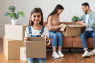 Mutlu genç aile kutuları topluyor ya da açıyor.