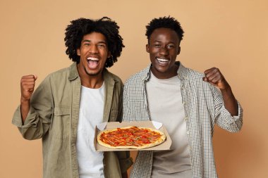 Yemek teslimatı. İki Neşeli Siyah Adam Lezzetli Pizzalı Kutuyu Tutuyor