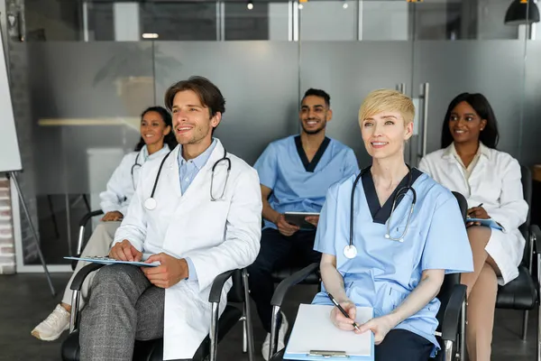 Grupo multirracial de médicos en ropa de trabajo que asisten a una conferencia médica —  Fotos de Stock