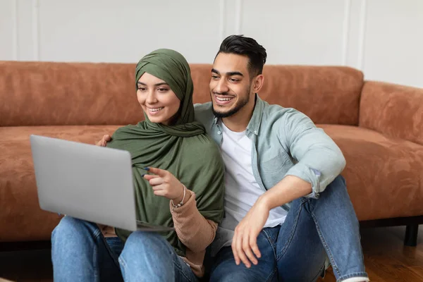 Felice uomo musulmano e donna utilizzando il computer portatile che punta allo schermo — Foto Stock