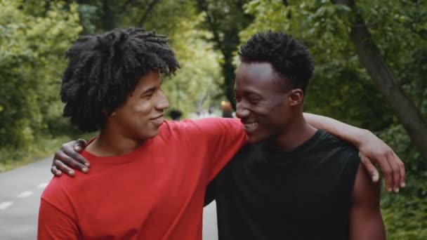 两个非裔美国人拥抱交谈，笑着站在外面 — 图库视频影像