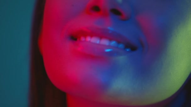 Close up portrait of young pretty asian woman posing to camera in bright colorful neon lights and smiling — Stock Video