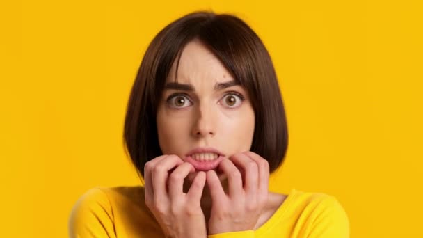 Ansiosa jovem mulher preocupante sofrendo de ansiedade sobre fundo amarelo — Vídeo de Stock
