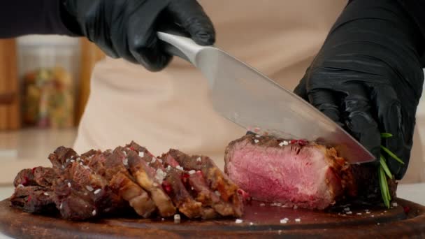 Nerozpoznatelný kuchař bourání hovězí maso vaření hovězí steaky v kuchyni, oříznuté — Stock video