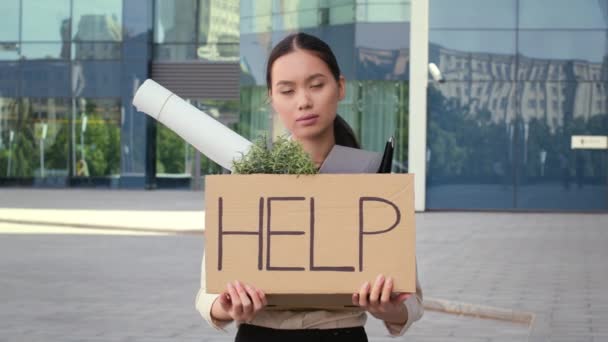 Desempleado asiático hembra celebración caja de cartón con palabra ayuda fuera — Vídeo de stock