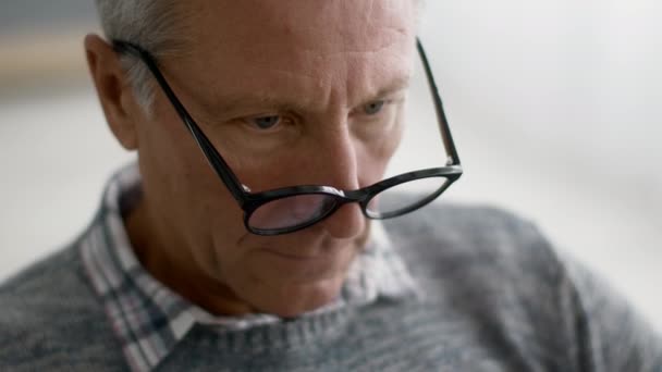 Closeup Shot Of Senior Man Wearing Eyeglasses Reading Something, Eyes Following Text — Stock Video