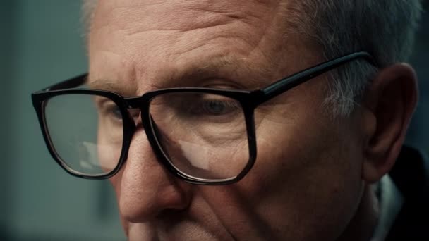 Closeup van volwassen zakenman dragen bril werken op computer binnen — Stockvideo