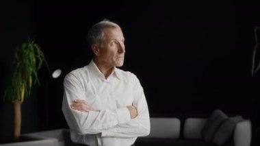 Kendine güvenen orta yaşlı iş adamı yeni ofisine bakıyor.