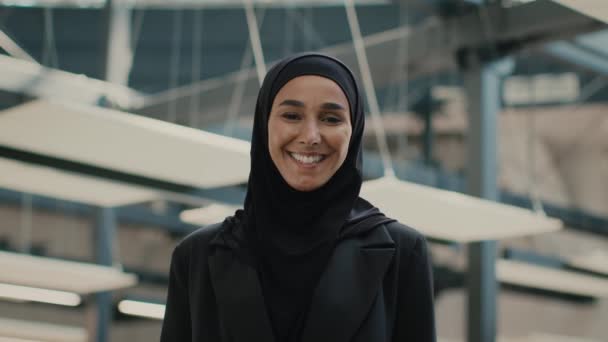 Исламская леди носит хиджаб, улыбаясь в камеру, стоящую на посту — стоковое видео