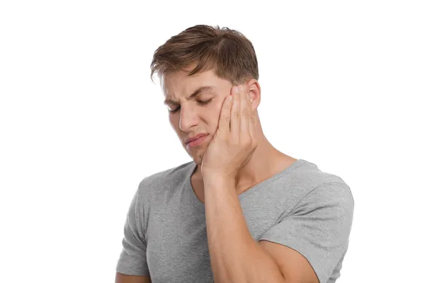 Infeliz triste milenar caucasiano homem pressiona mão para bochecha e sofre de dor de dente — Fotografia de Stock