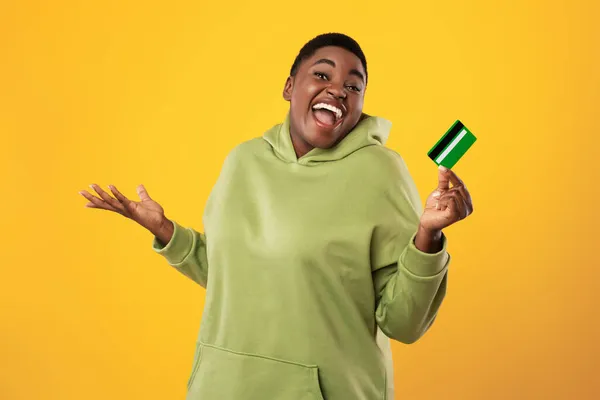Joyful Plus Size Black Woman Holding Credit Card Over Yellow Background — Stock Photo, Image