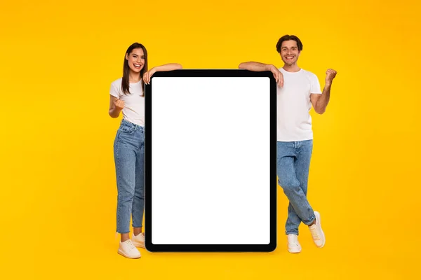 Paar zeigt weißen leeren Tablet-Bildschirm und gestikuliert ja — Stockfoto