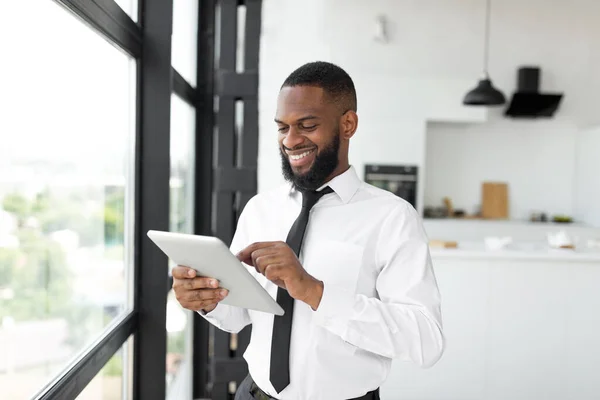 Hombre afroamericano usando tableta digital mirando la pantalla —  Fotos de Stock